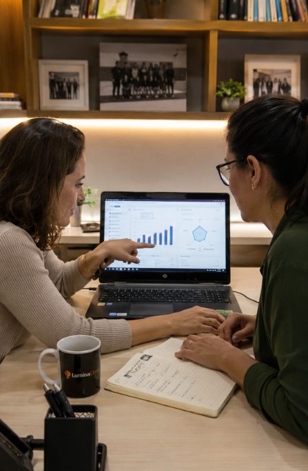 Coordenadora e professora analisando juntas o painel de evolução por competência da Lumina Class no notebook
